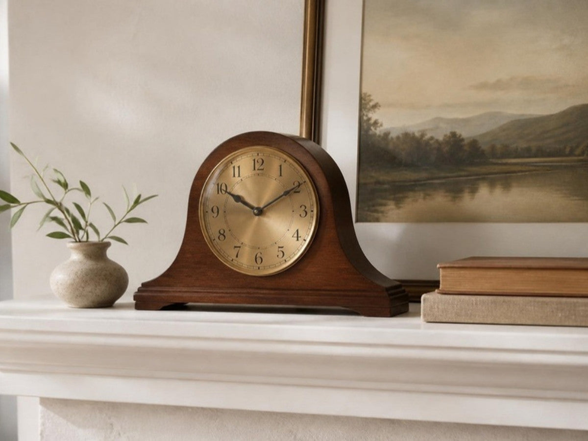 Walnut mantel clock with a brass dial on a white fireplace mantel